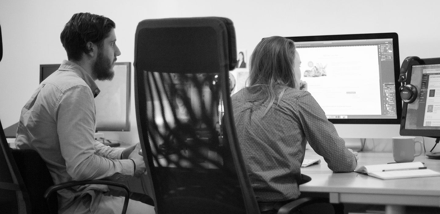 Web design team reviewing a website layout on screen in the studio.